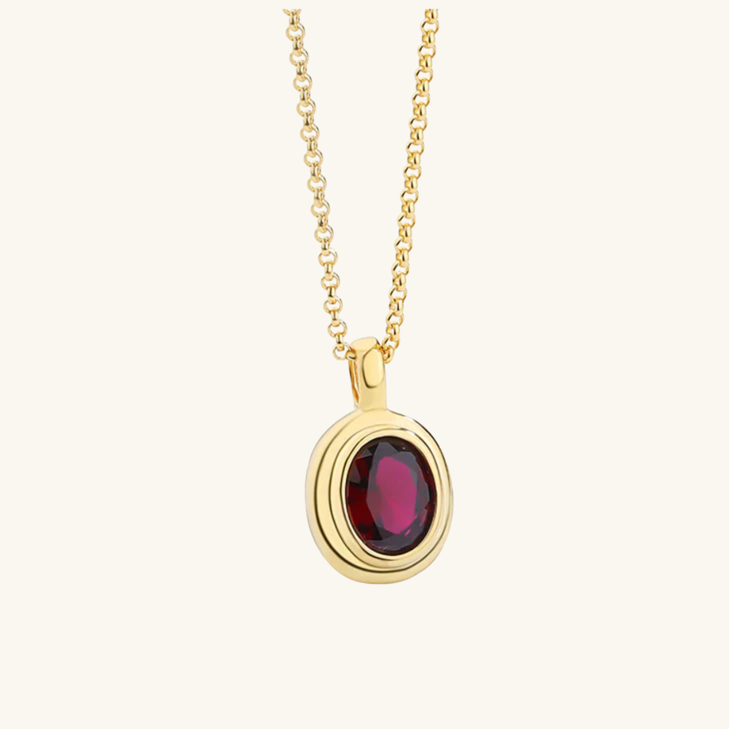 Gold necklace with a red gemstone pendant on a white background