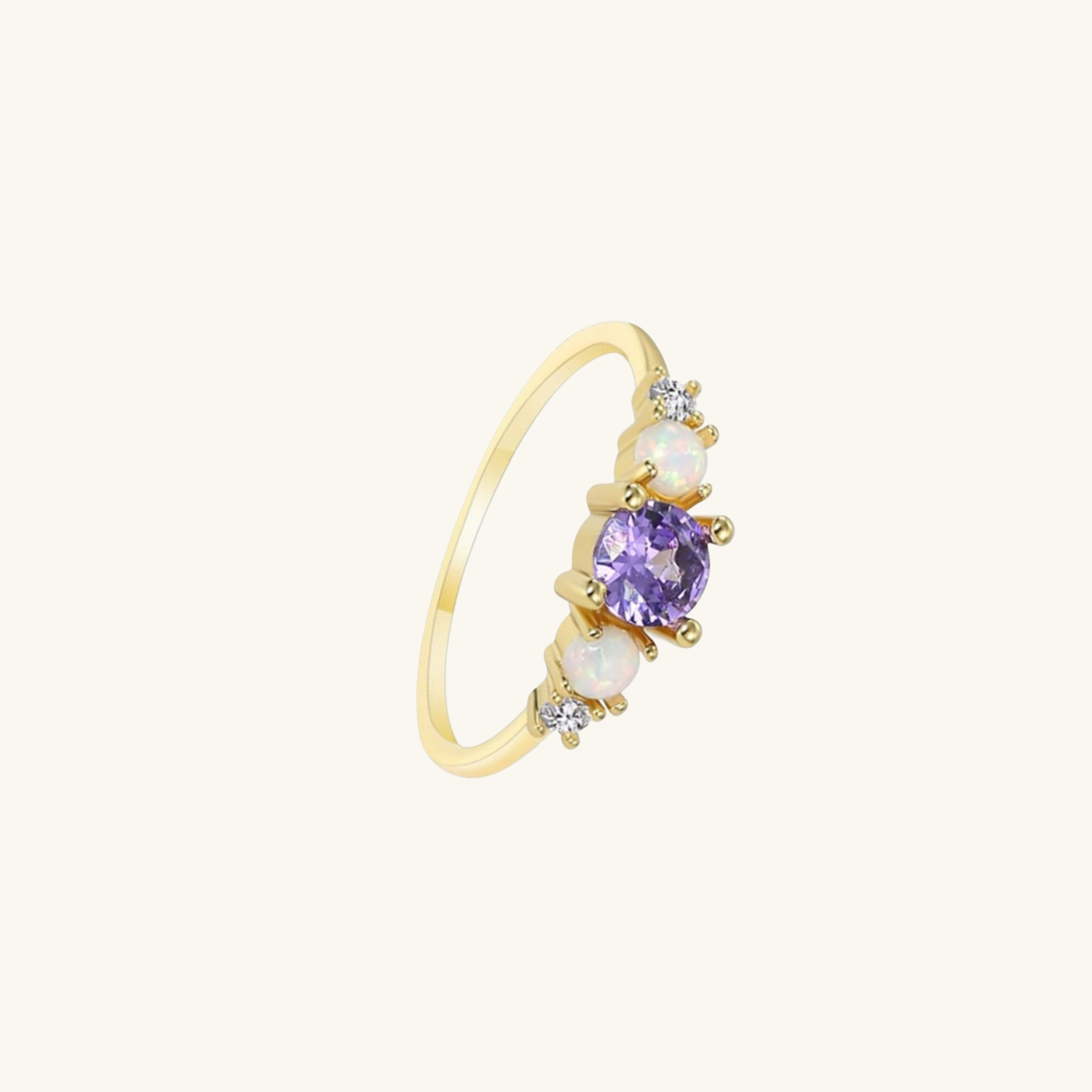 Gold ring with a purple gemstone and opalite on a white background