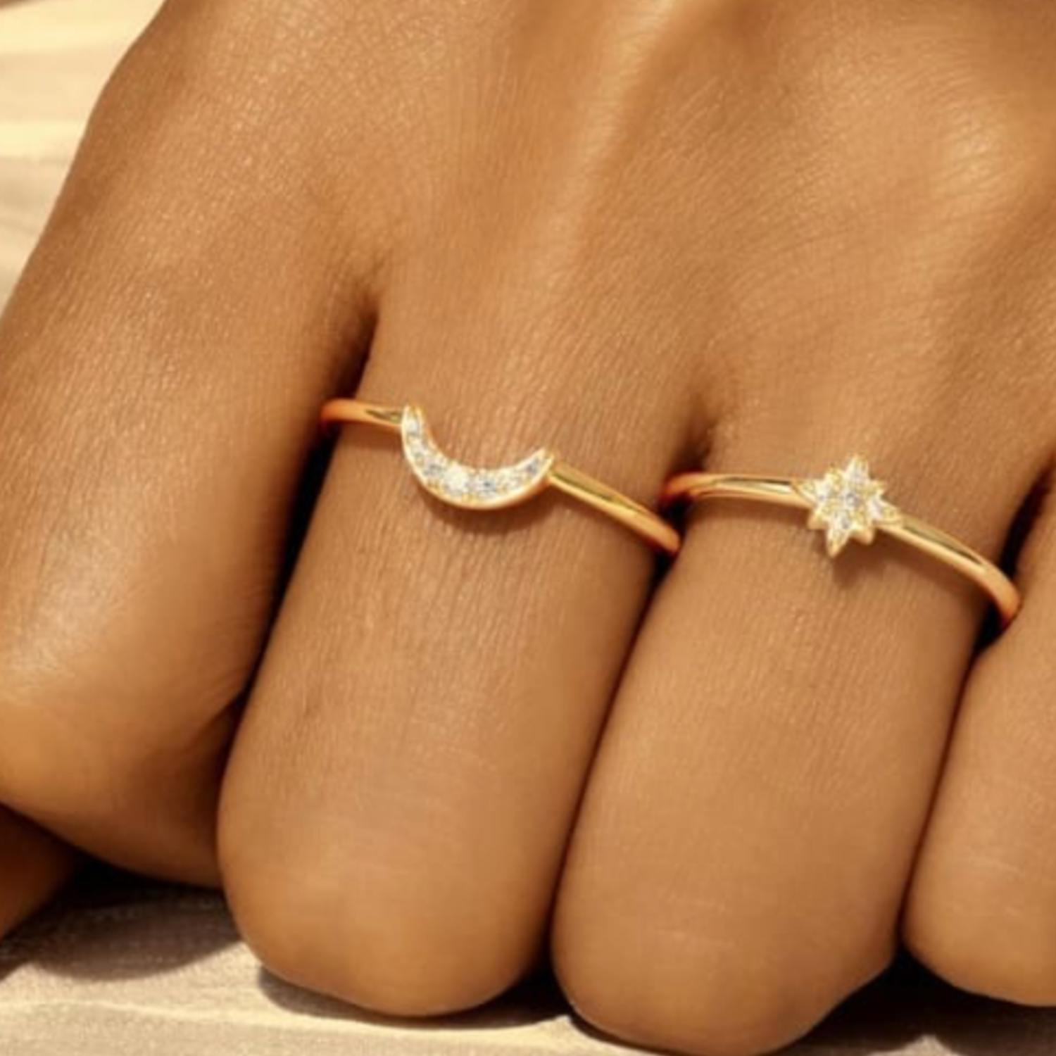 Two gold rings with diamond accents on a person's fingers.