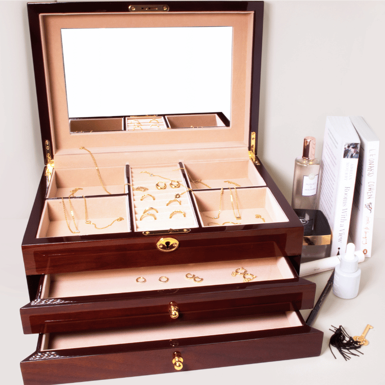 Open wooden jewellery box with jewellery inside, showing ring section  and different compartments