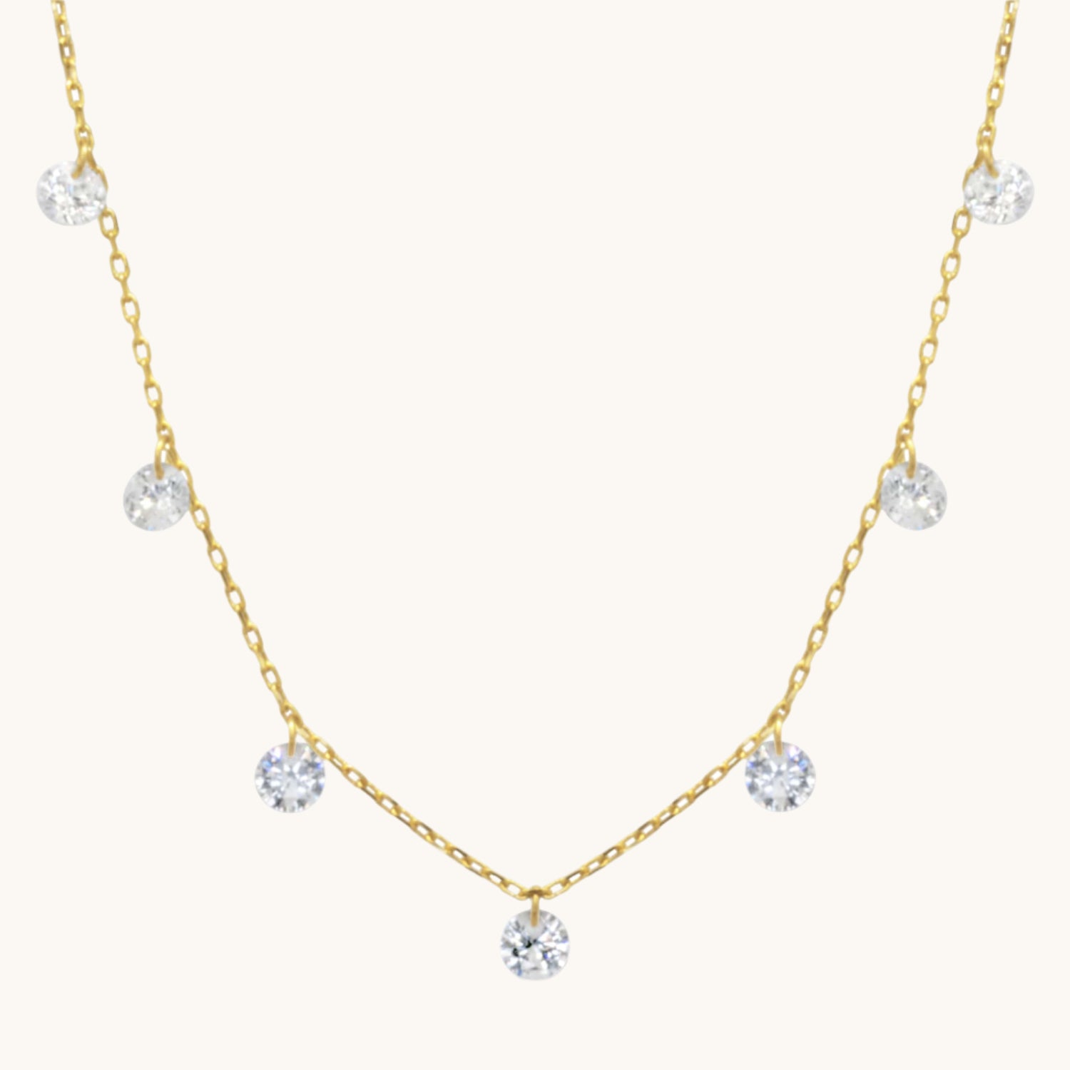 Pretty Cubic Zirconia Drop gold Necklace  pictured on warm cream background