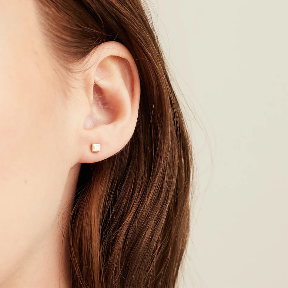 Model wearing gold square zircon earrings