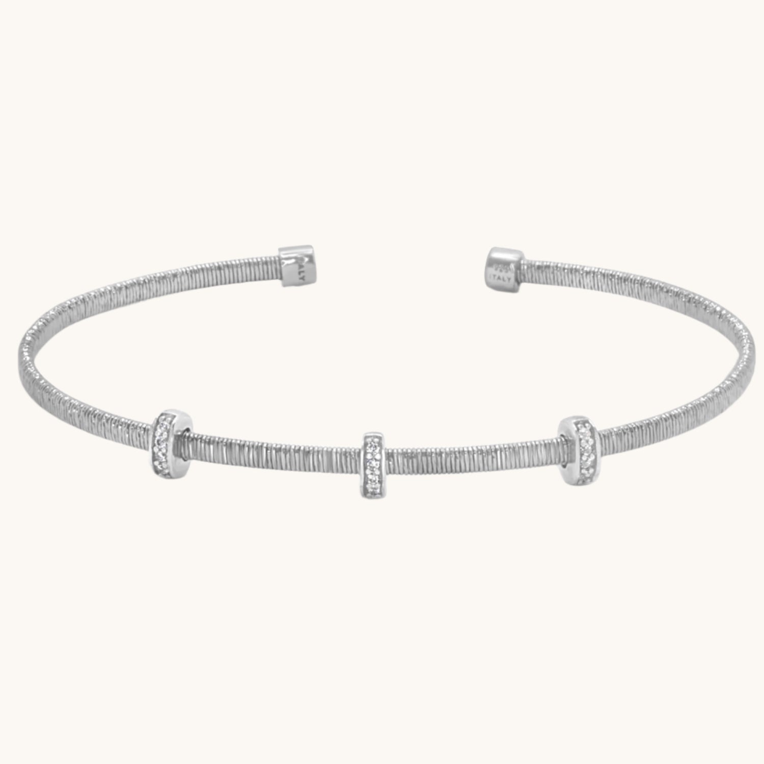 Flat lay of three rondel diamond cut bangles with a sparkling, faceted texture