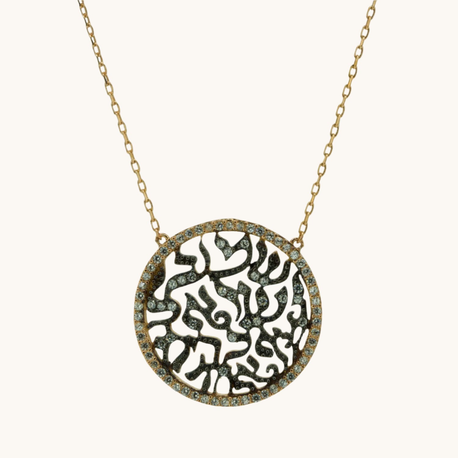 Shema pendant with cubic zirconia, on cream background