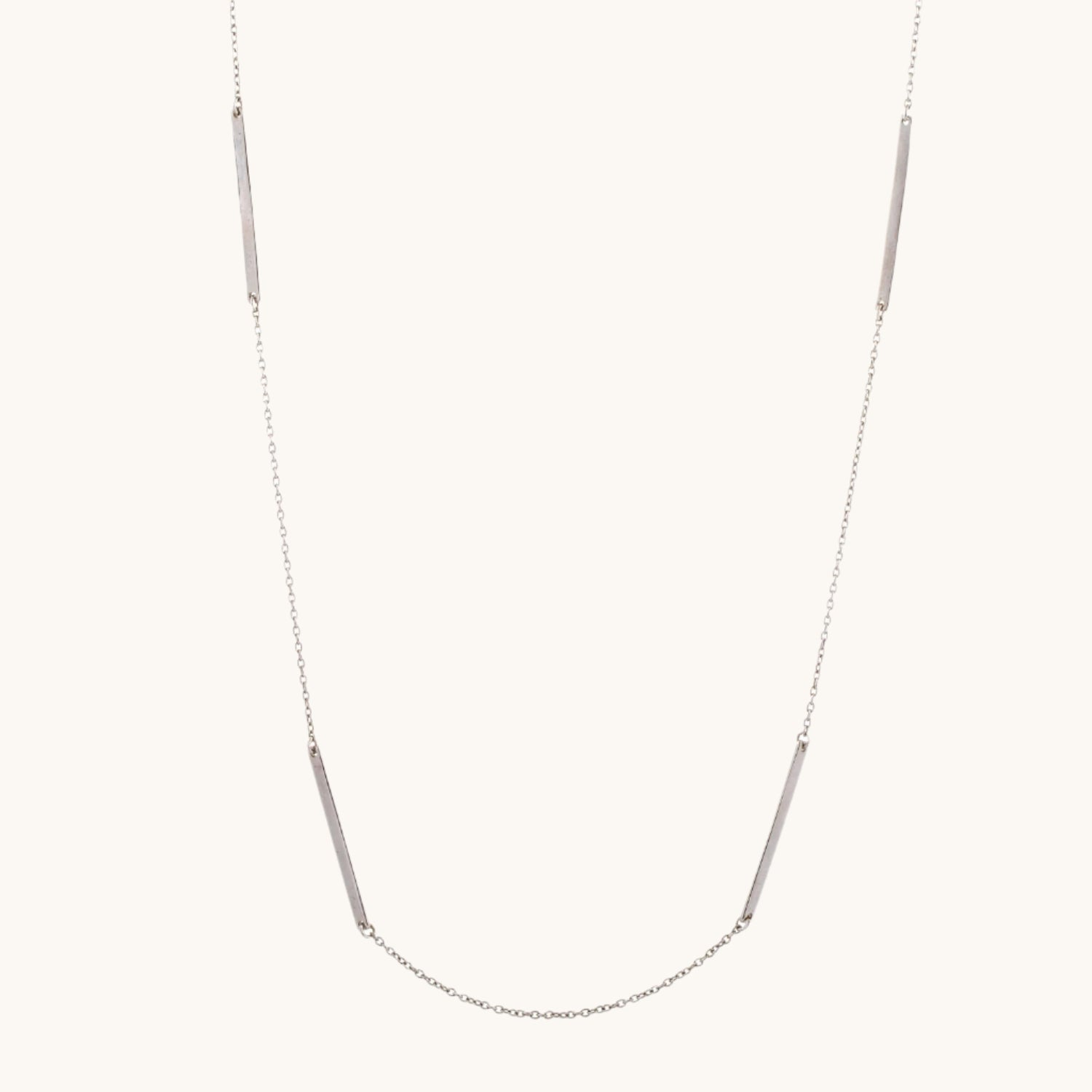 Classic Long Bar Necklace in sterling silver displayed on warm cream background