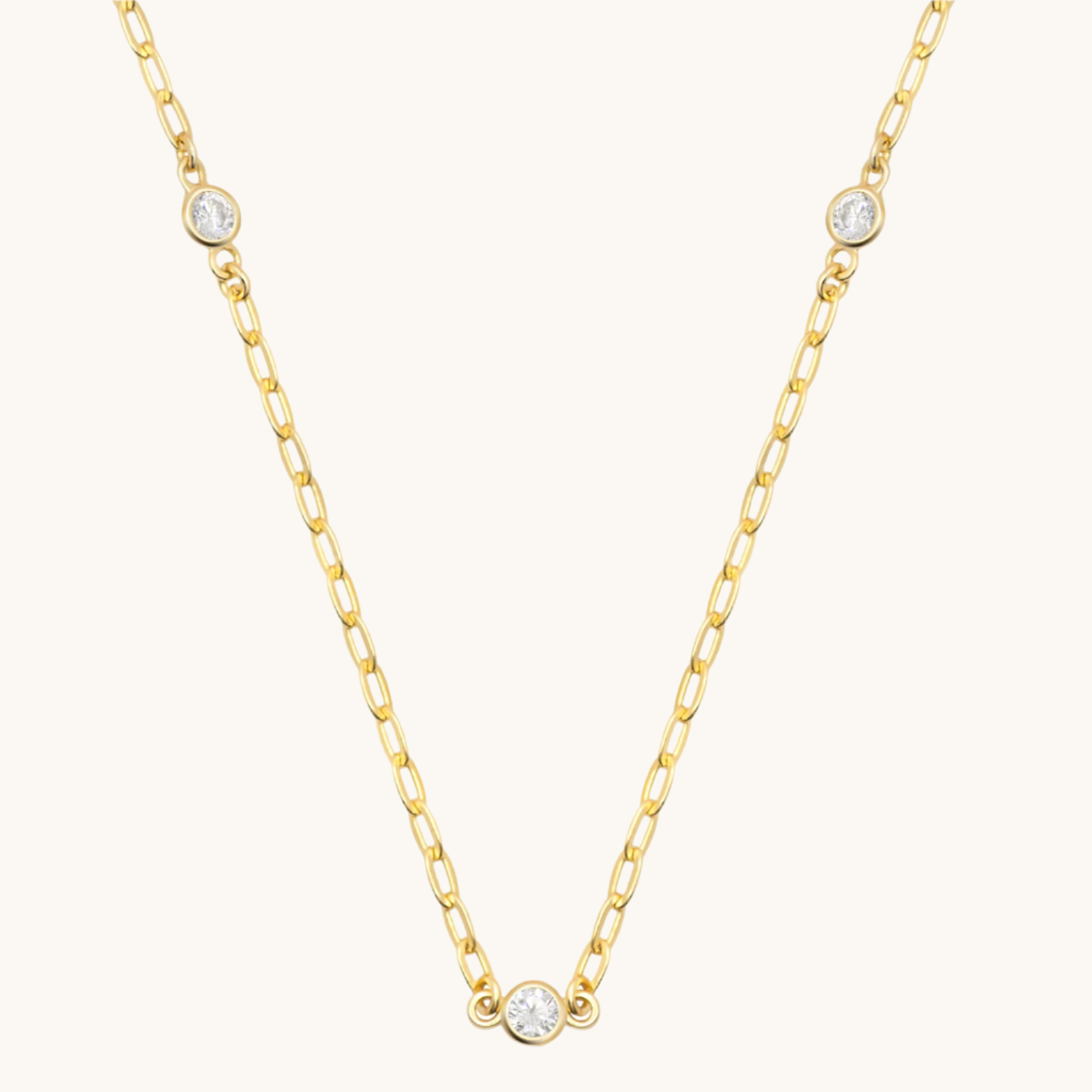 gold paperclip chain with cubic zirconia  along necklace length. Shown on cream background