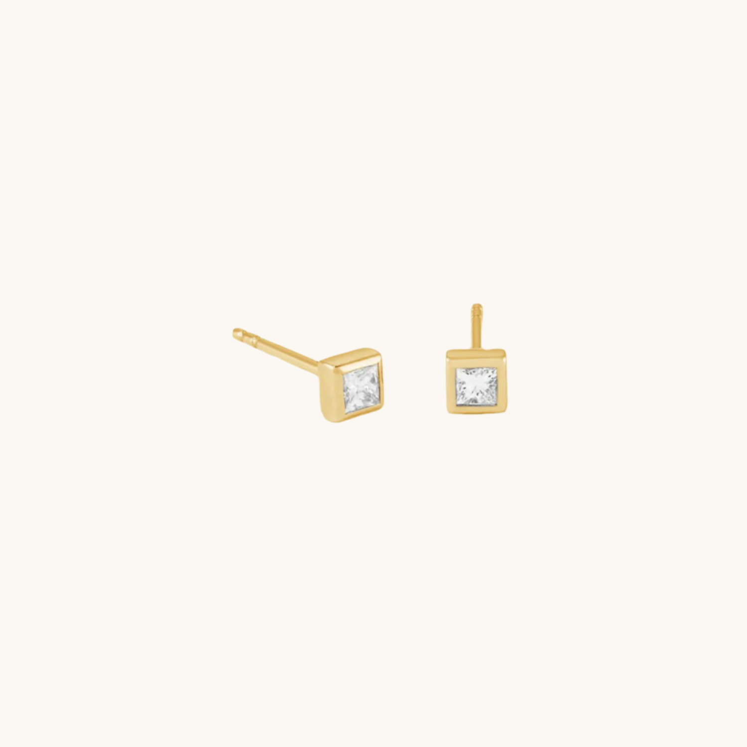 gold square zircon earrings shown on cream background