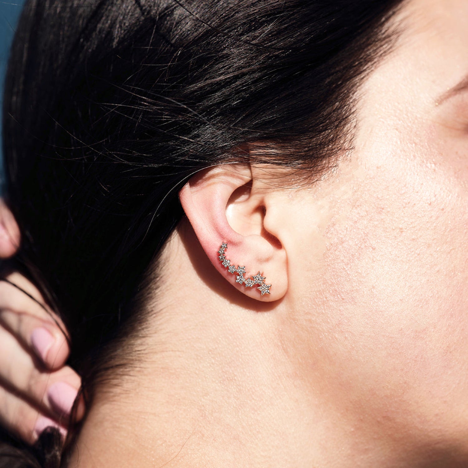 Model wears star cuff earrings